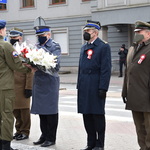 Przedstawiciele służb mundurowych pod pomnikiem przekazują kwiaty obsłudze mundurowej