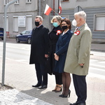 Delegacja Powiatu Płońskiego stoi przed pomnikiem konstytucji w Płońsku po złożeniu kwiatów