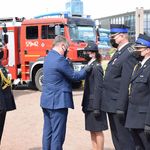 Nagrodzeni strażacy stoją w szeregu podczas otrzymywania odznaczeń