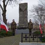 Dwuosobowa warta stoi przy pomniku zamordowanych płońszczan na Piaskach po obydwu stronach stoją flagi Polski